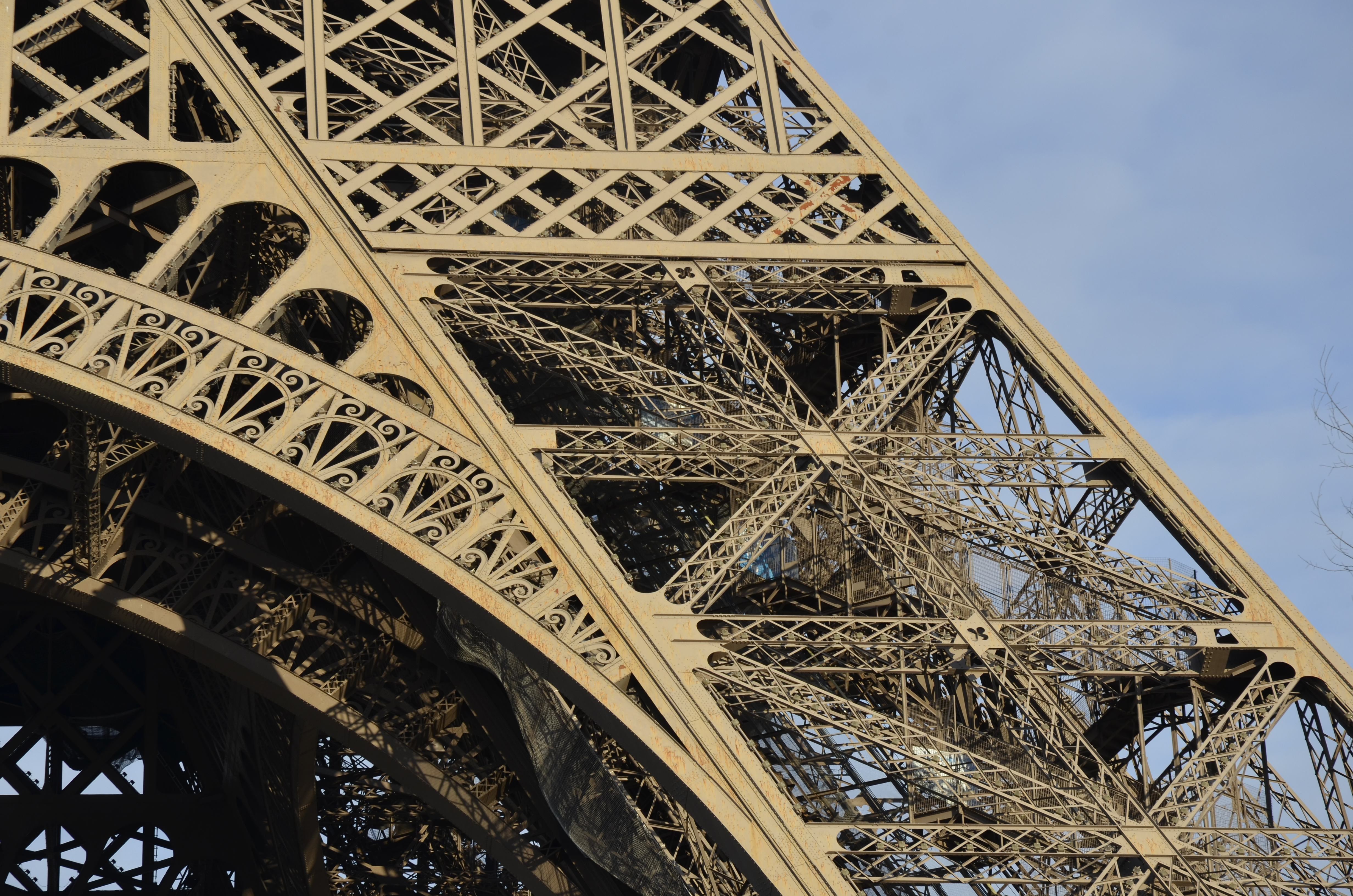 Close-up of the Eiffel Tower’s intricate iron lattice against a clear sky